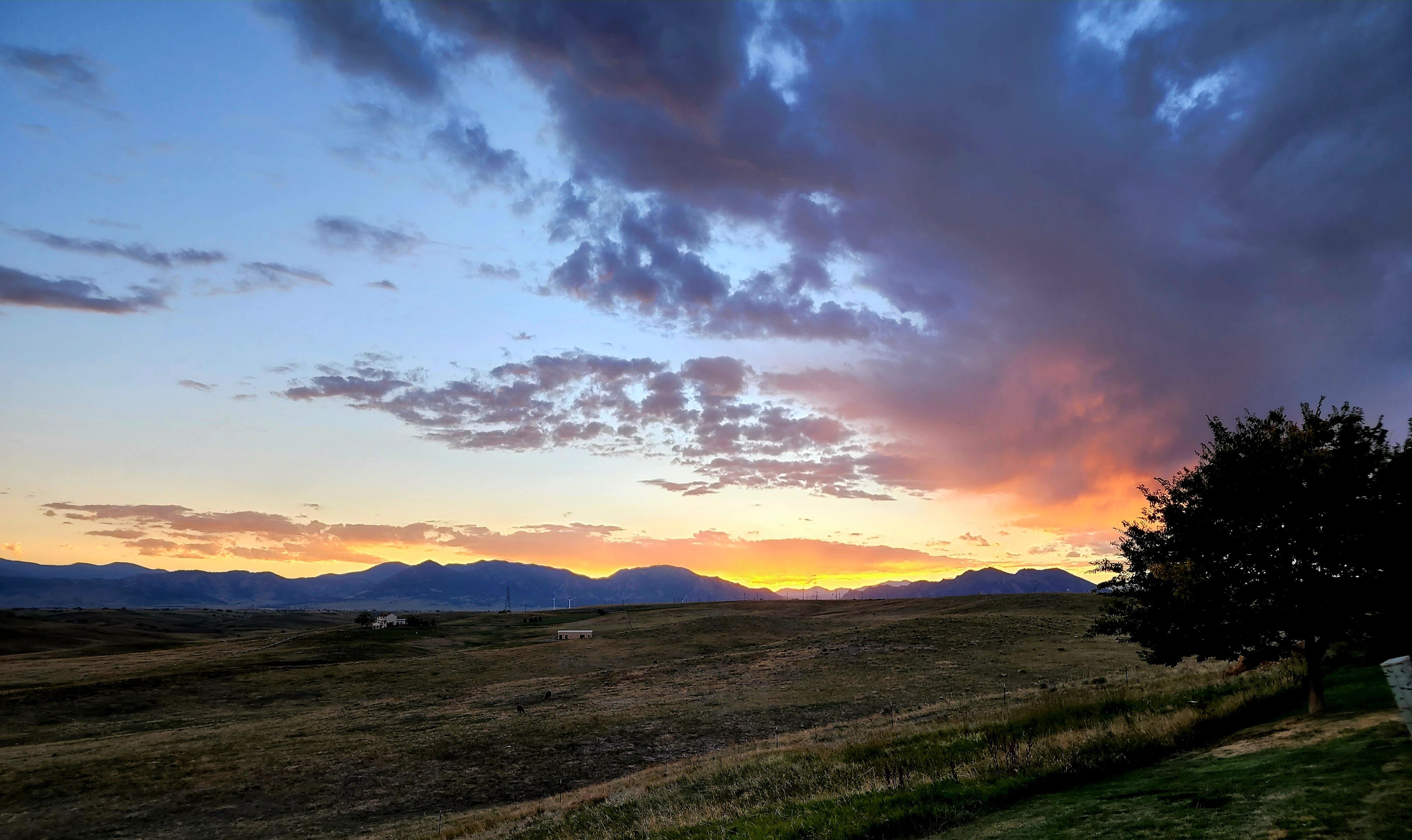Sunset over the Colorado foothills, seen across open grassland from a Front Range neighbourhood